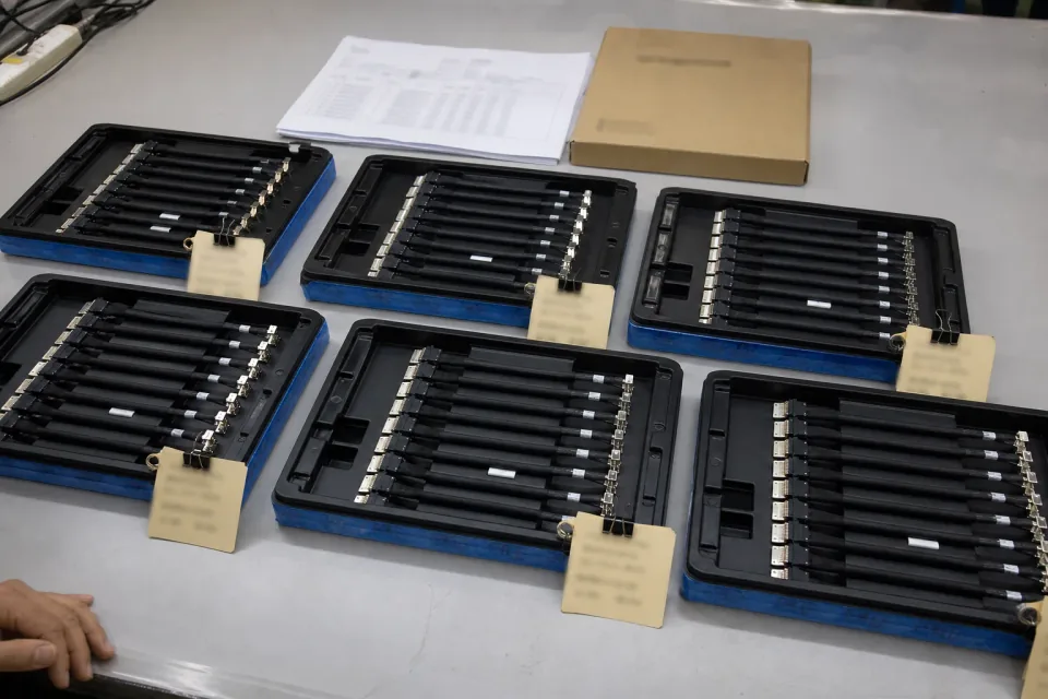 Lot-traceability staging area for a CABLINE-compatible micro-coax program, multiple ESD lot trays of micro-coax harnesses with neutral, unreadable traceability tags